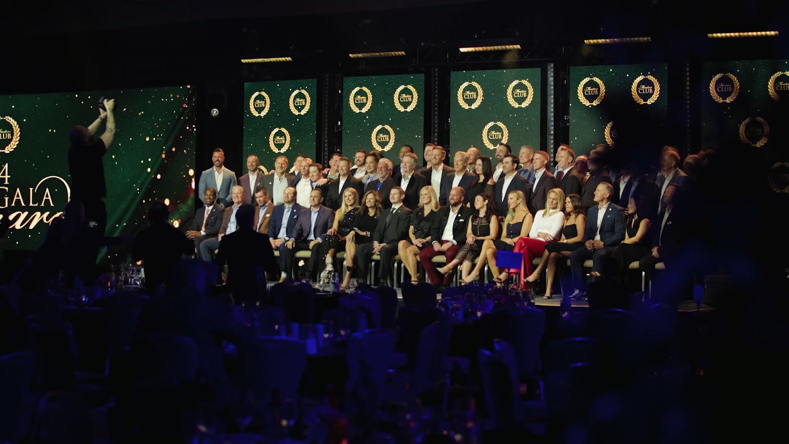 [CONFIRM] Gala dinner audience in a decorated ballroom.