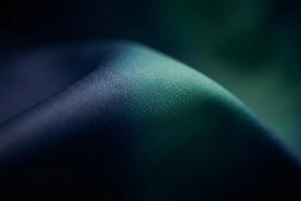 Close-up of the printed booth wall fabric where deep navy blends into a teal aurora gradient.